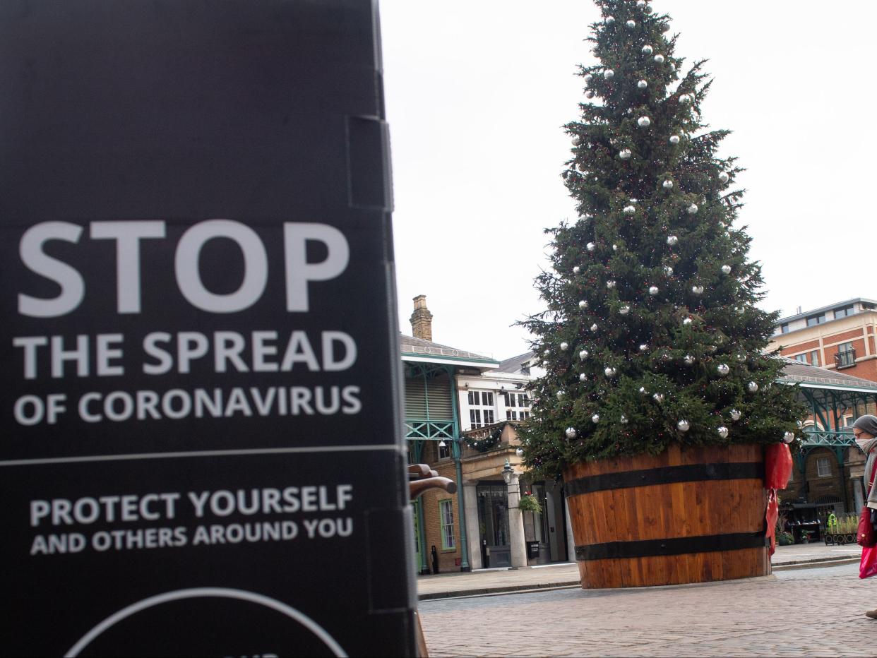 A sign warning about coronavirus near a Christmas tree at Covent Garden, London (PA)