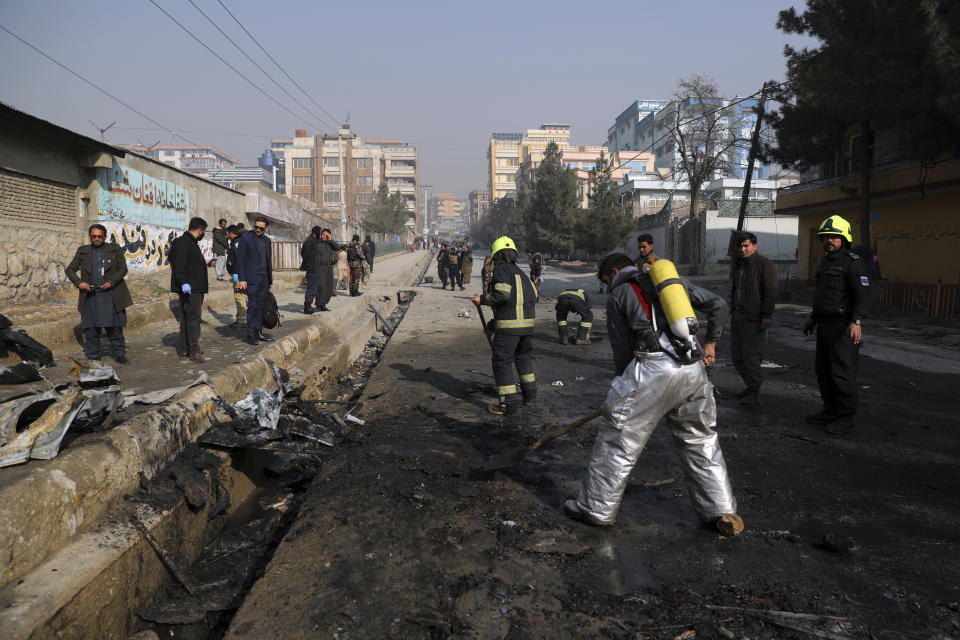 Afghan firefighters work at the site of a bombingh attack in Kabul, Afghanistan, Sunday, Jan. 10, 2021. A roadside bomb exploded in Afghanistan's capital Sunday, killing at least a few people in a vehicle, the latest attack to take place even as government negotiators are in Qatar to resume peace talks with the Taliban. (AP Photo/Rahmat Gul)