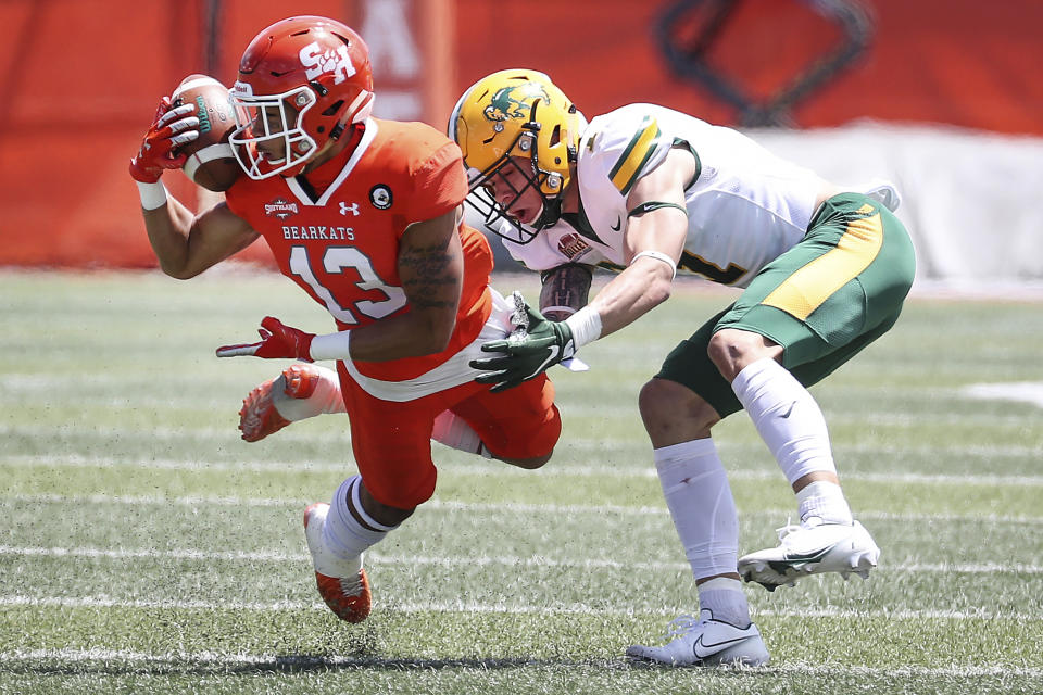 Sam Houston State defensive back Isaiah Downes (13) intercepts a pass intended for North Dakota State wide receiver Christian Watson (1) during the first quarter of a quarterfinal game in the NCAA college FCS football playoffs on Sunday, May 2, 2021, in Huntsville, Texas. (Brett Coomer/Houston Chronicle via AP)