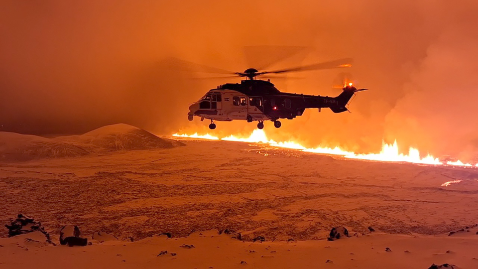 An Icelandic coast guard helicopter flies near the volcanic eruption (AFP via Getty Images)