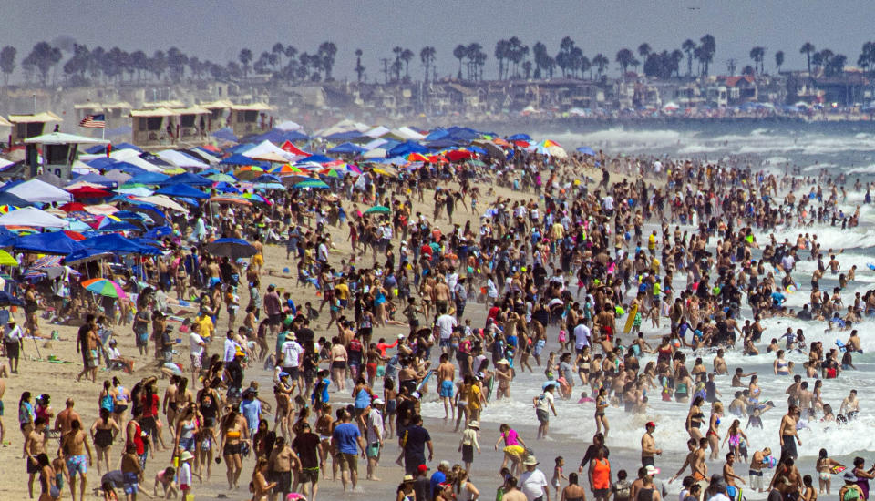 FILE - This July 28, 2019 file photo shows thousands of people on the sand during the U.S. Open of Surfing in Huntington Beach, Calif., in Orange County. The Southern California county between Los Angeles and San Diego long known as a GOP stronghold now has more registered Democrats than Republicans. Orange County's Registrar of Voters reports Wednesday, Aug. 7, 2019, there are 89 more Democrats than Republicans among its 1.6 million registered voters. (Mindy Schauer/The Orange County Register via AP, File)/