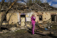 Iryna Martsyniuk, 50, stands next to her house, heavily damaged after a Russian bombing in Velyka Kostromka village, Ukraine, Thursday, May 19, 2022. Martsyniuk and her three young children were at home when the attack occurred in the village, a few kilometres from the front lines, but they all survived unharmed. (AP Photo/Francisco Seco)