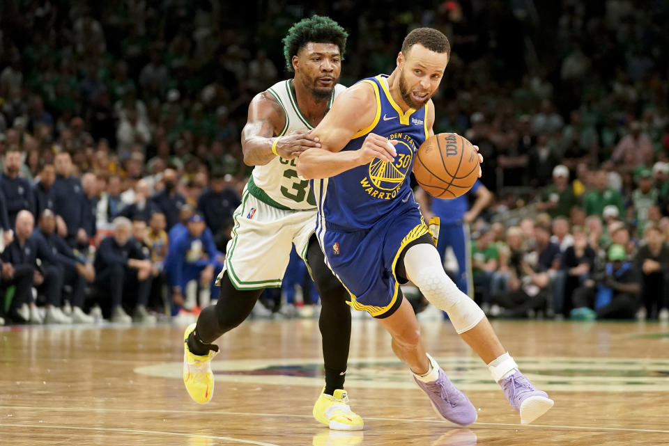 Golden State Warriors guard Stephen Curry (30) drives against Boston Celtics guard Marcus Smart (36) during the fourth quarter of Game 6 of basketball's NBA Finals, Thursday, June 16, 2022, in Boston. (AP Photo/Steven Senne)