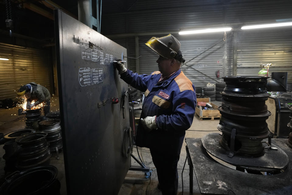 A volunteer draws a mark on a board as he takes into account after welding the next heating stove in a workshop in Siauliai, some 230 km (144 miles) north-west of the capital Vilnius, Lithuania, Thursday, Feb. 2, 2023. Since Russia invaded Ukraine last February, Lithuania, Latvia and Estonia — three states on NATO’s eastern flank scarred by decades of Soviet-era occupation — have been among the top donors to Kyiv. (AP Photo/Sergei Grits)