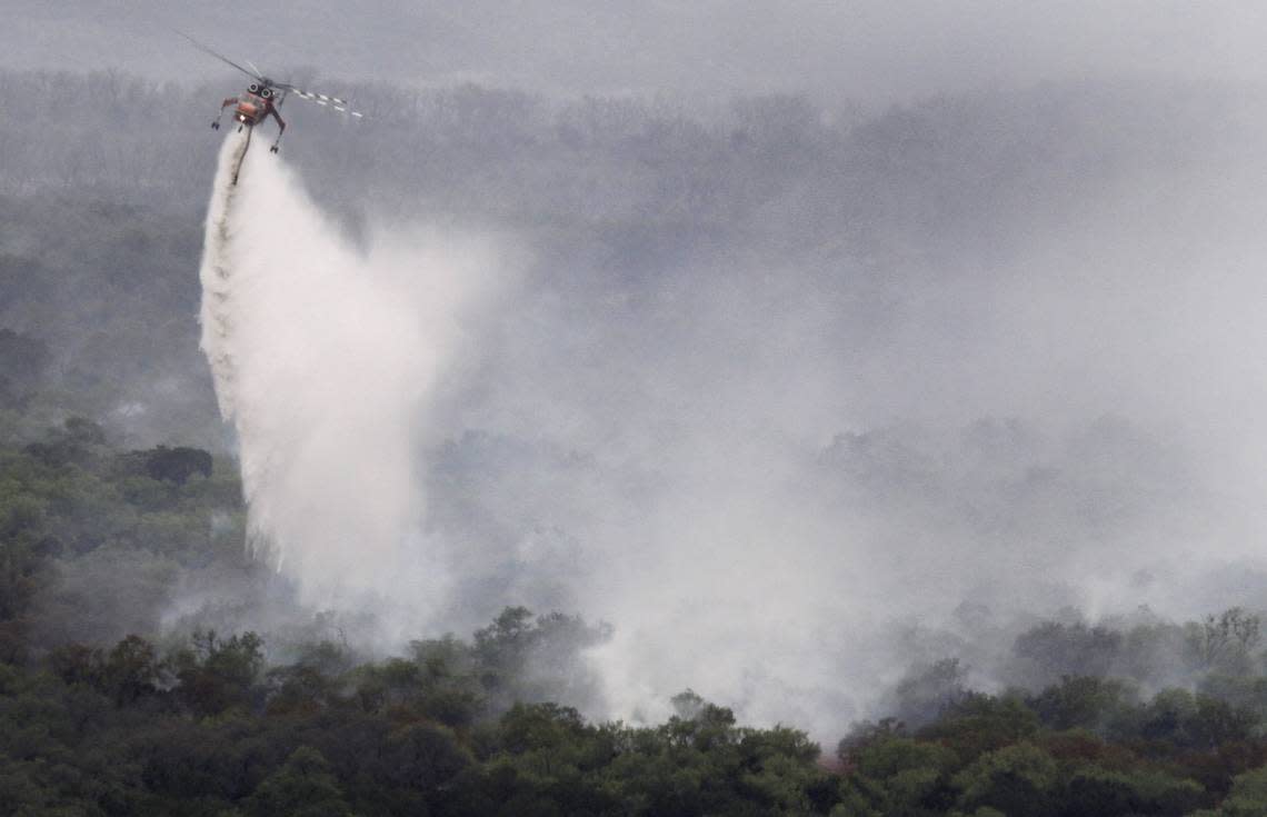 A K-MAX helicopter drops water on fires around Possum Kingdom Lake on April 20, 2011, during the Possum Kingdom Complex Fire, which was one of the most destructive in state history. Another wildfire has broken out in the area this week.