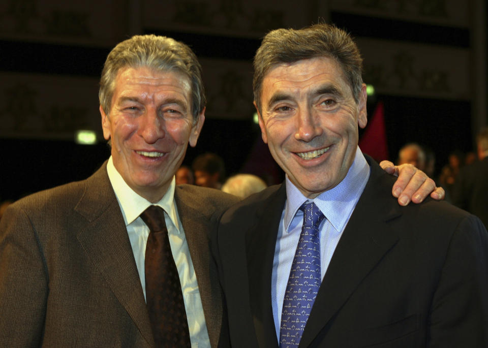 FILE - In this Saturday, Nov. 12, 2005 file photo, Former cycling World Champions Felice Gimondi, left, and Eddie Merckx, of Belgium pose for photographers before the start of the presentation of the 2006 edition of the 'Giro d' Italia' (Tour of Italy), in Milan, Italy. Gimondi died in Giardini Naxos, Sicily, southern Italy, Friday, Aug. 16, 2019, he was 76, Italian ANSA news agency said. (AP Photo/Luca Bruno, File)