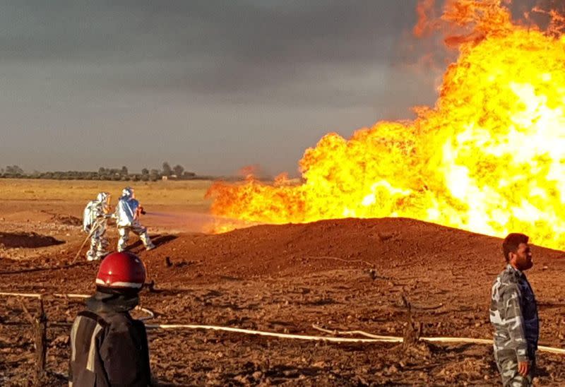 A firefighter sprays water on the fire that resulted from an explosion on the Arab Gas Pipeline between the towns of Ad Dumayr and Adra, northwest of the capital of Damascus