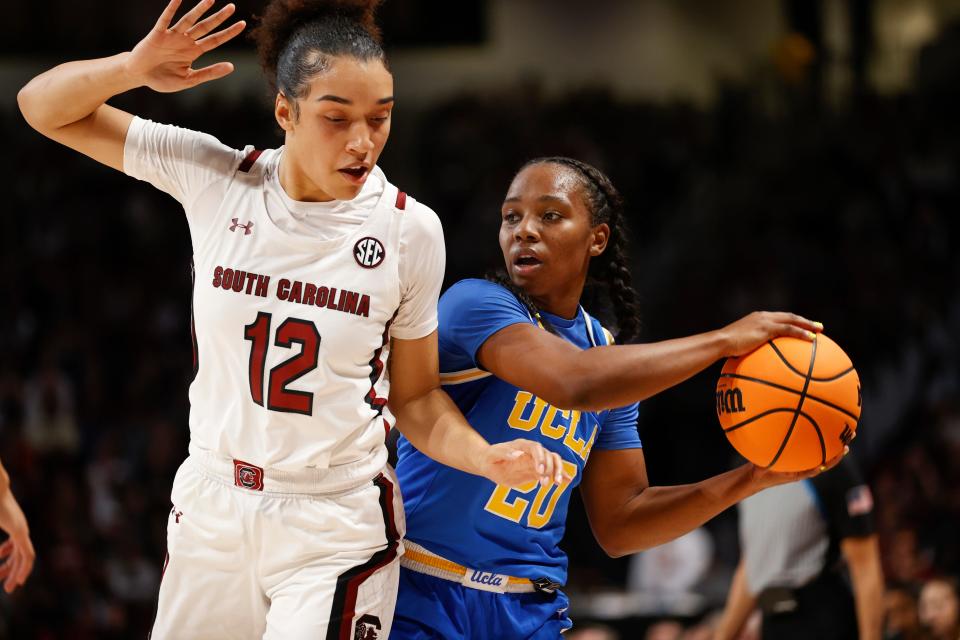 UCLA guard Charisma Osborne, right, looks to pass around South Carolina guard Brea Beal (12) during the first half of an NCAA college basketball game in Columbia, S.C., Tuesday, Nov. 29, 2022. (AP Photo/Nell Redmond)