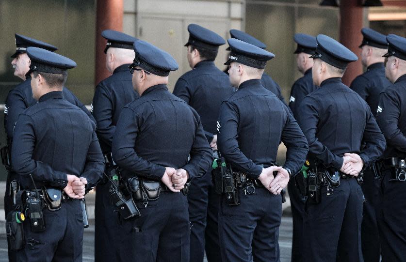 Los Angeles police officers stand at role call prior to a ceremony marking the 20th anniversary of an infamous gunbattle between police and two heavily armed bank robbers in Los Angeles on Tuesday, Feb. 28, 2017. The gathering Tuesday morning honored the officers involved in the February 1997 shootout that changed the way police departments nationwide arm officers. (AP Photo/Richard Vogel)