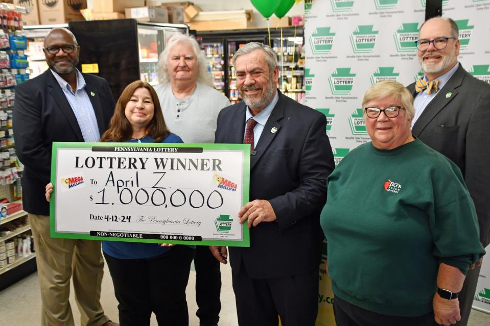 Pennsylvania Secretary of Revenue Pat Browne presents a commemorative check Thursday, April 25, to April Zipp, the winner of a $1 million Mega Millions lottery ticket purchased at BG’s Value Market in Jonestown.