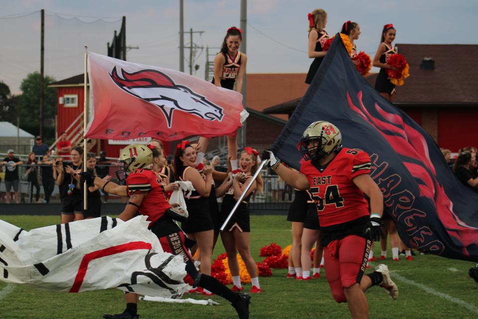 Members of the Bullitt East High School football team run onto the field before a game Friday, Aug. 26, 2022, against Spencer County. The Chargers fell to the Bears 19-16.