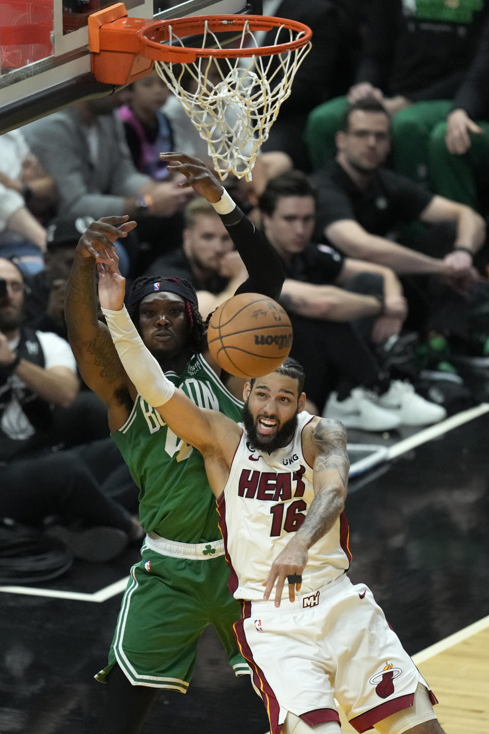 Miami Heat forward Caleb Martin (16) and Boston Celtics center Robert Williams III vie for a rebound during the second half of Game 6 of the NBA basketball Eastern Conference finals, Saturday, May 27, 2023, in Miami. (AP Photo/Rebecca Blackwell)