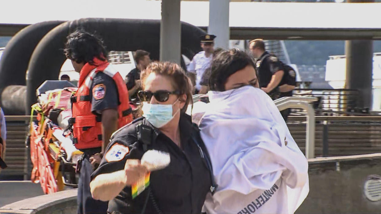 First responders help people who were rescued from a boat on the Hudson River on July 12, 2022. (NBC NY)