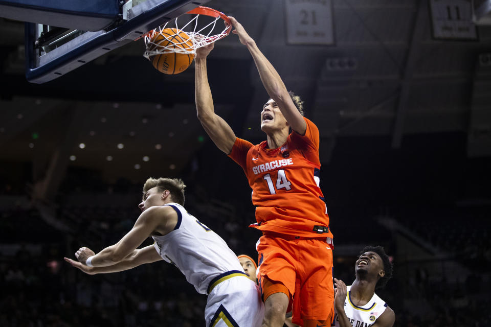 Syracuse's Jesse Edwards (14) dunks over Notre Dame's Dane Goodwin, left, as Trey Wertz, right, watches during an NCAA college basketball game on Saturday, Dec. 3, 2022 in South Bend, Ind. (AP Photo/Michael Caterina)