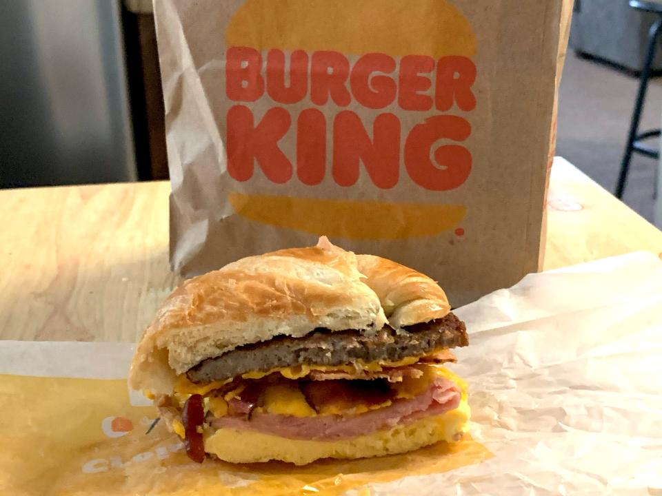 Burger King fully loaded Crossain'wich in front of brown bag