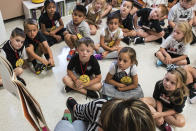 FILE — In this Aug. 22, 2018, file photo, students from two kindergarten classes at the Lewiston elementary campus of Saint Dominic Academy, listen to a teacher read a book, in Lewiston, Maine. School districts across the United States are hiring additional teachers in anticipation of what will be one of the largest kindergarten classes ever as enrollment rebounds following the pandemic. (Russ Dillingham/Sun Journal via AP, File)