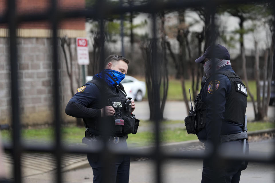 Memphis police stand behind a locked gate at a precinct as a group of demonstrators arrive outside to protest the death of Tyre Nichols, who died after being beaten by Memphis police officers, in Memphis, Tenn., Sunday, Jan. 29, 2023. (AP Photo/Gerald Herbert)