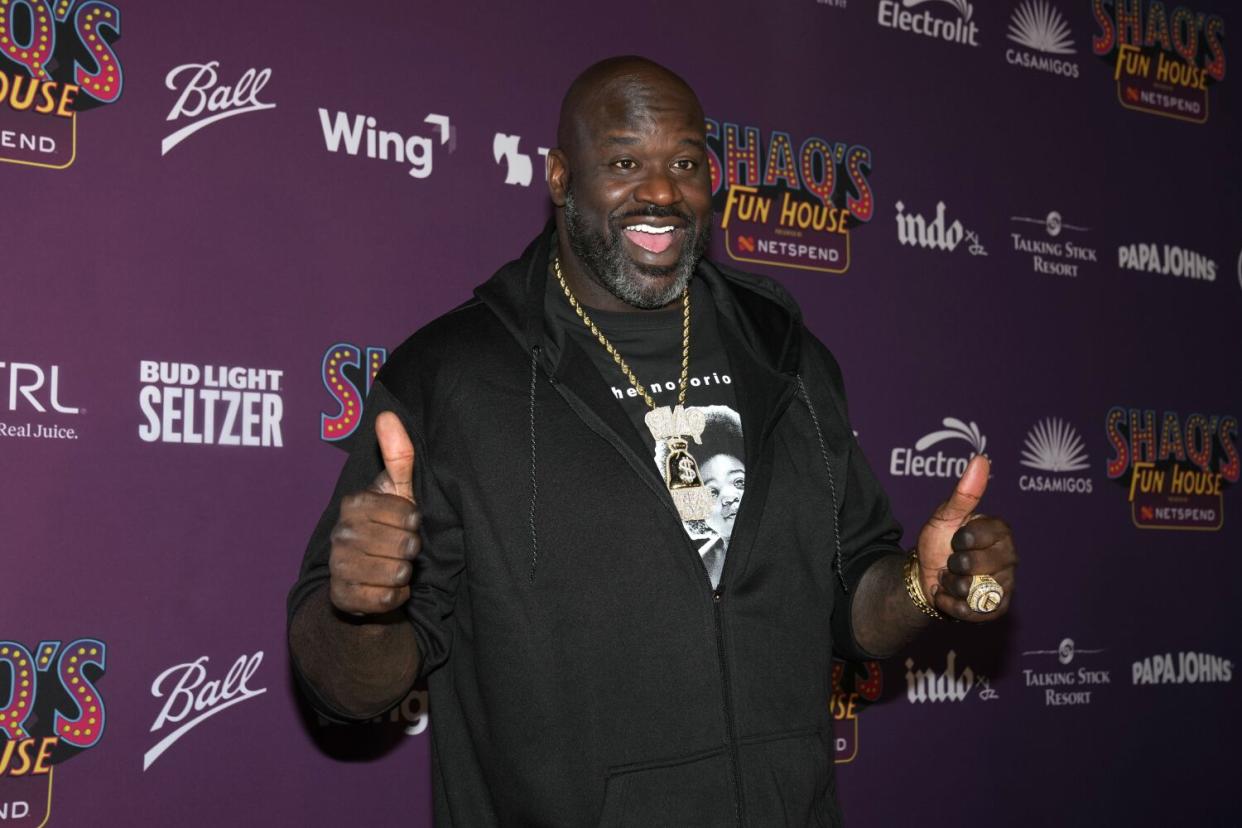Shaquille O'Neal flashes a thumbs up on the red carpet while attending Shaq's Fun House Super Bowl event.