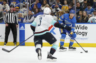 St. Louis Blues' Alexey Toropchenko (13) looks to pass the puck while Seattle Kraken's Will Borgen (3) defends during the second period of an NHL hockey game Saturday, Oct. 14, 2023, in St. Louis. (AP Photo/Scott Kane)