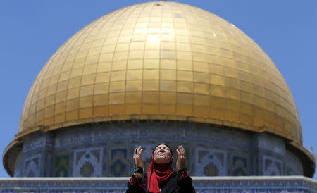 FILE PHOTO: A Palestinian woman prays in front of the Dome of the Rock on the first Friday of the holy month of Ramadan at the compound known to Muslims as the Noble Sanctuary and to Jews as Temple Mount, in Jerusalem's Old City June 19, 2015. REUTERS/Ammar Awad/File Photo