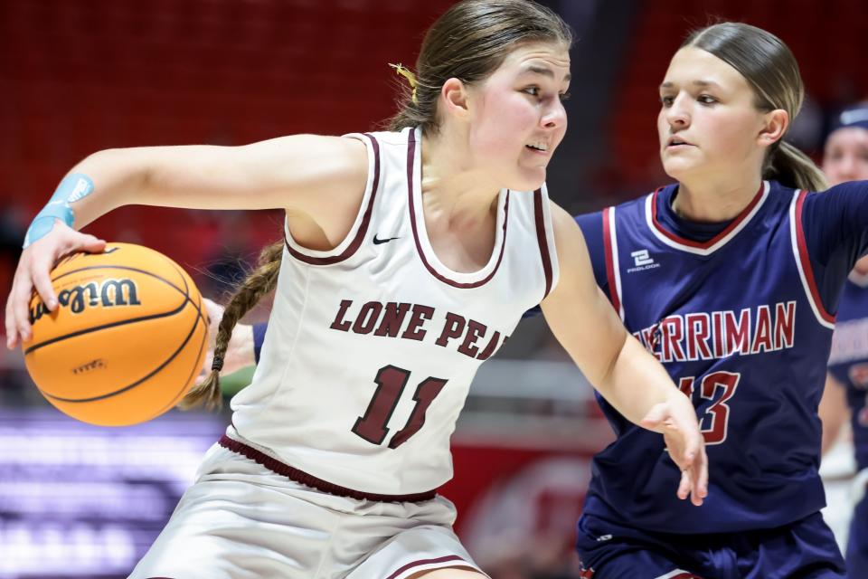 Lone Peak’s Kailey Woolston, wearing white, drives against Herriman’s Kenlee Enger