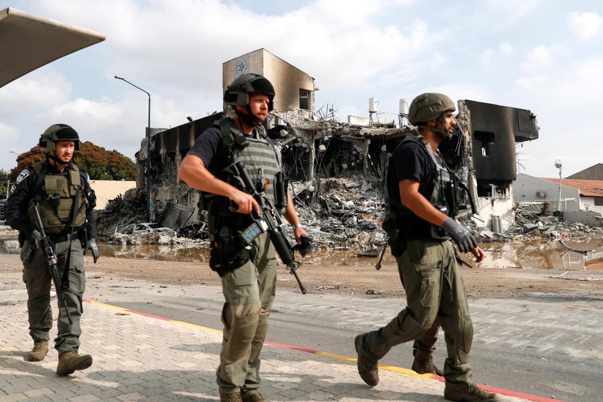 Israeli security forces walk outside the destroyed police station that was controlled by Hamas militants in the southern city of Sderot (EPA/ATEF SAFADI)