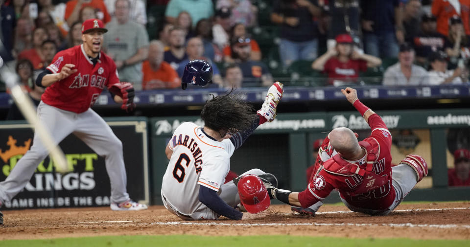 Houston Astros' Jake Marisnick, (6) collides Los Angeles Angels catcher Jonathan Lucroy (20) while trying to score during the eighth inning of a baseball game Sunday, July 7, 2019, in Houston. Marisnick was called out under the home plate collision rule. (AP Photo/David J. Phillip)