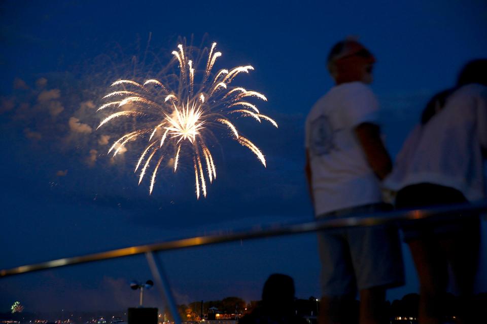 People watch the fireworks over the Toms River Sunday night, July 4, 2021, from a boat docked at the Lighthouse Point Marina & Yacht Club in South Toms River.