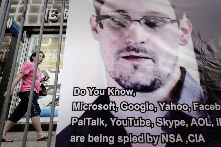 A woman walks past a banner displayed in support of former US spy Edward Snowden in Hong Kong on June 18, 2013. The United States pressed for Snowden's formal extradition from Hong Kong