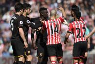 <p>Hull City’s Oumar Niasse is held back by Harry Maguire as Southampton’s Oriol Romeu looks on </p>