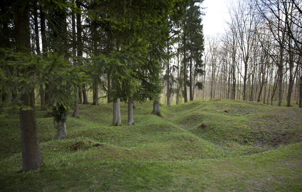 FILE- Grass and trees cover World War I bomb craters in the ruined village of Fleury devant Douaumont, France, on April 3, 2017. With war ravaging Europe's heartland again, the countless headstones, cemeteries and memorials from World War I are a timeless testimony to its cruelty. Belgium and France want them recognized as UNESCO World Heritage sites to make sure people stop and think. (AP Photo/Virginia Mayo, File)