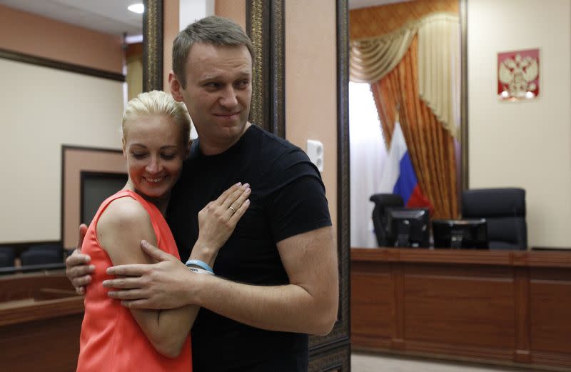 Russian opposition leader Alexei Navalny embraces his wife Yulia inside a court building in Kirov