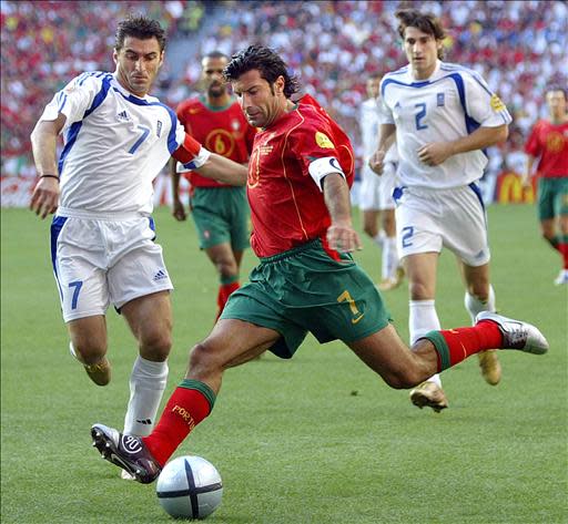 Portuguese forward Luís Figo (R) is about to kick the ball next to Greek midfielder Theodoros Zagorakis, 04 July 2004 at the Luz stadium in Lisbon, during the Euro 2004 final match between Portugal and Greece at the European Nations football championship in Portugal. AFP PHOTO Lluis GENE