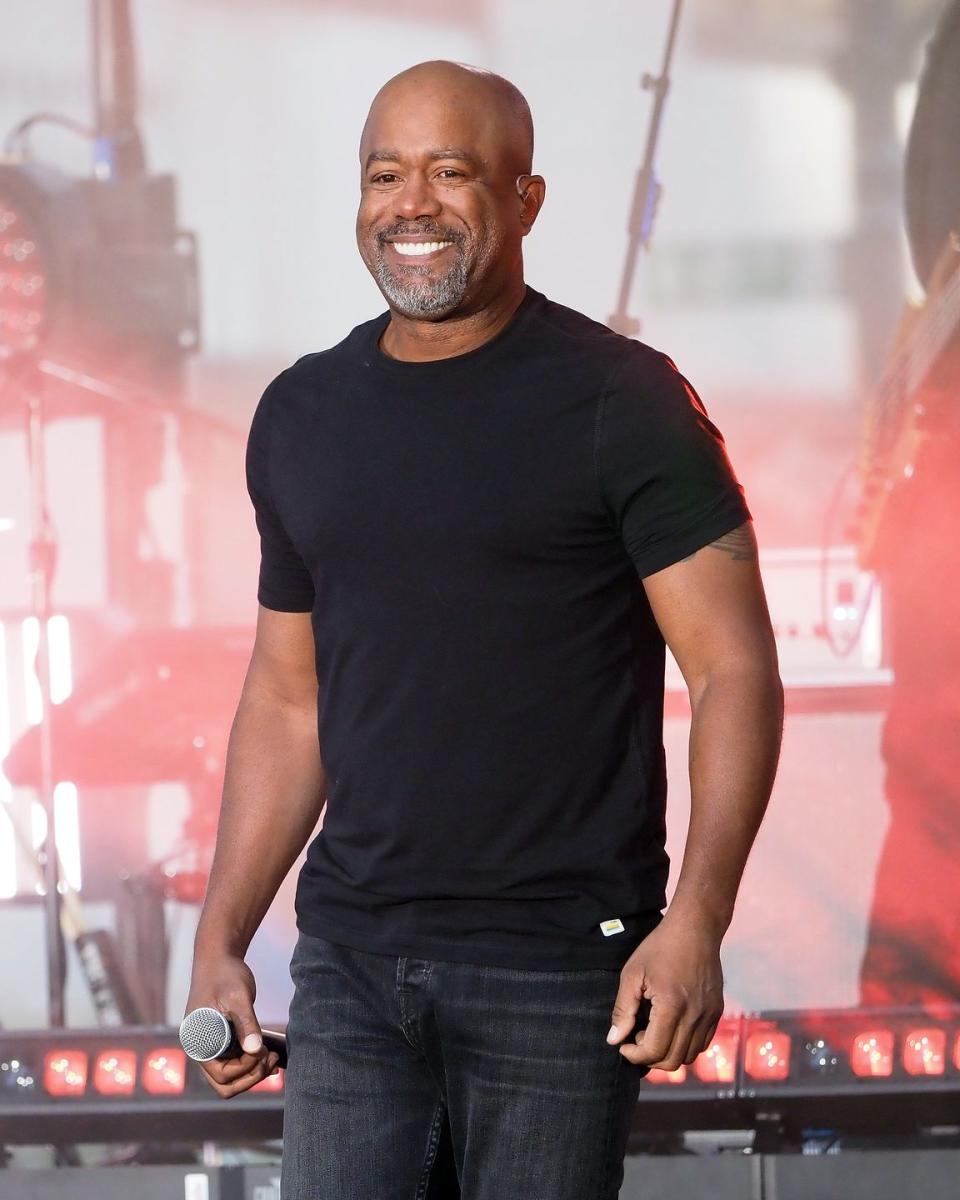 darius rucker smiling on stage as he takes a break during a performance