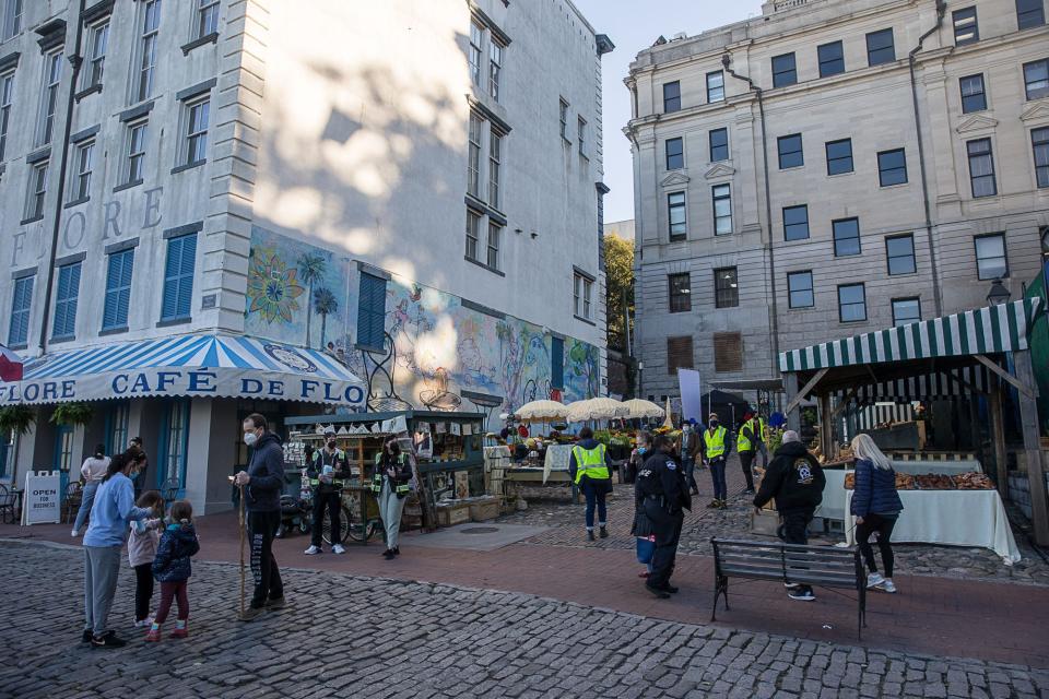 Crew members walk around the closed set for 'Devotion' as they prepare for filming on River Street. The set includes a market along the ramp next to Olympia Cafe, which has been transformed into a French hotel and café. (Photo: Richard Burkhart/Savannah Morning News)