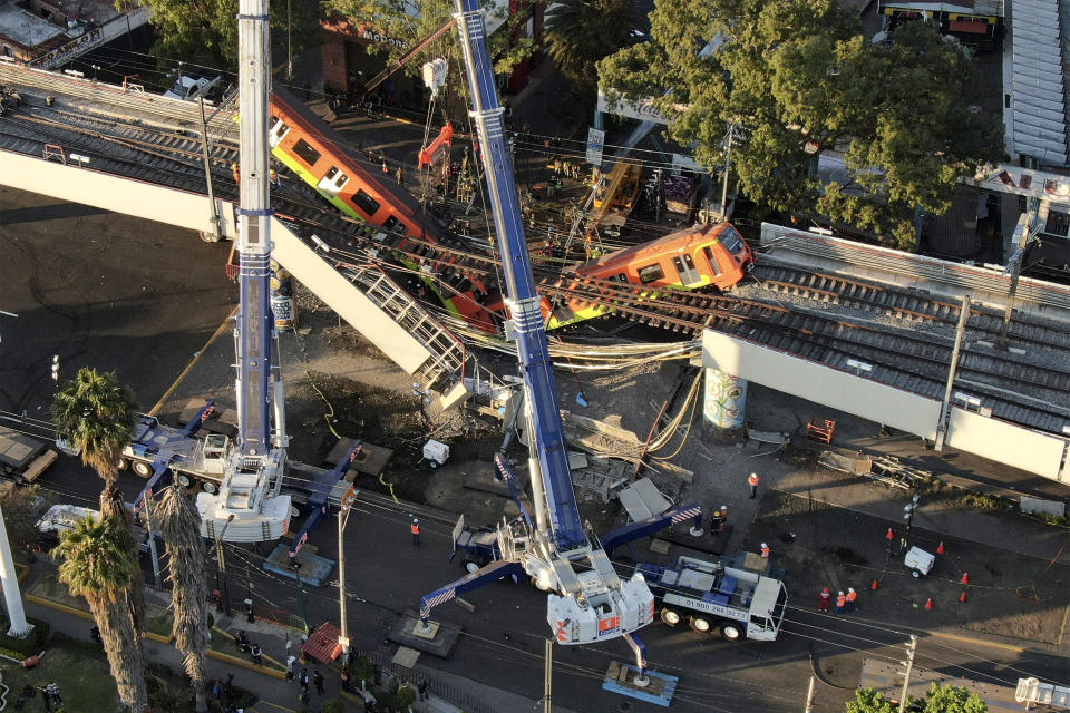 Image: Subway cars dangle at an angle from a collapsed elevated section of the metro, in Mexico City on May 4, 2021. (Fernando Llano / AP)