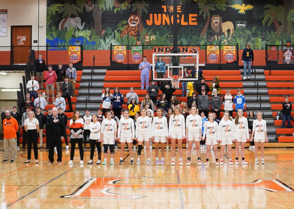 The Tecumseh girls basketball team stands for the national anthem prior to Friday's game against Adrian.