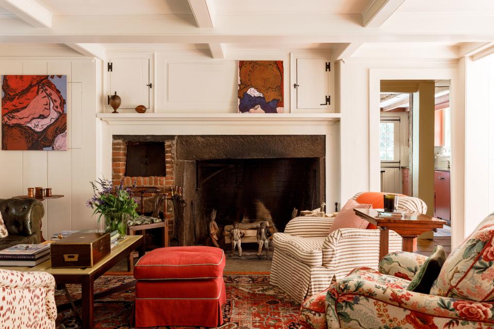 Another section of the sitting room—what was actually once the kitchen hearth—features chairs upholstered in Colefax and Fowler and Brunschwig & Fils fabrics. Two pieces from contemporary artist Charles Billingham hang on the wall.