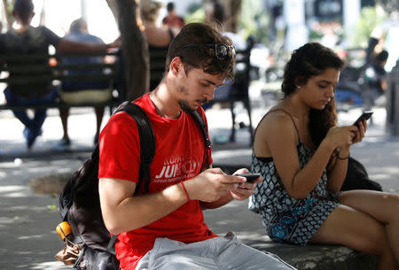 Miguel Hayes, who writes for the blog La Joven Cuba, connects to the internet at a hotspot in a park, in Havana, Cuba February 5, 2018. Picture taken February 5, 2018. REUTERS/Stringer