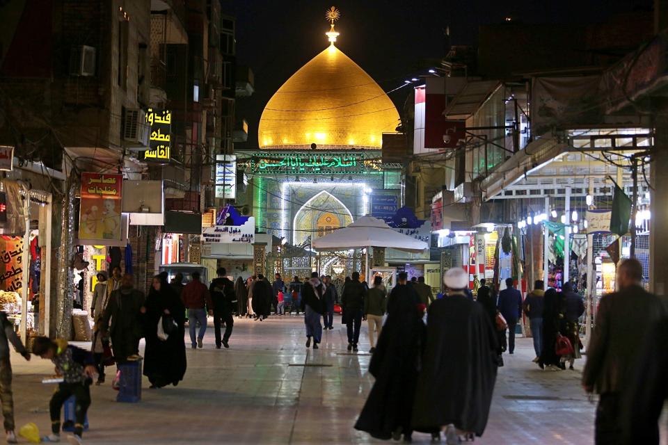 In this Thursday, Feb. 13, 2020 photo, people walk toward the holy shrine of Imam Ali, the son-in-law and cousin of the Prophet Muhammad and the first Imam of the Shiites, in Najaf, Iraq. In recent years, Valentine's in Najaf has emerged as a field of contention. It pitted revelers who see in it harmless fun and personal freedom advocates against conservatives who view it as sacrilege--a foreign celebration that has no place in a holy city like Najaf. (AP Photo/Anmar Khalil)