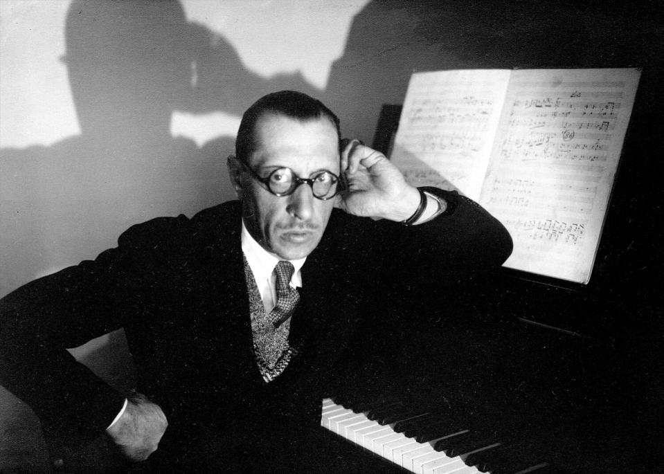 black and white photo of a man with round spectacles at a piano