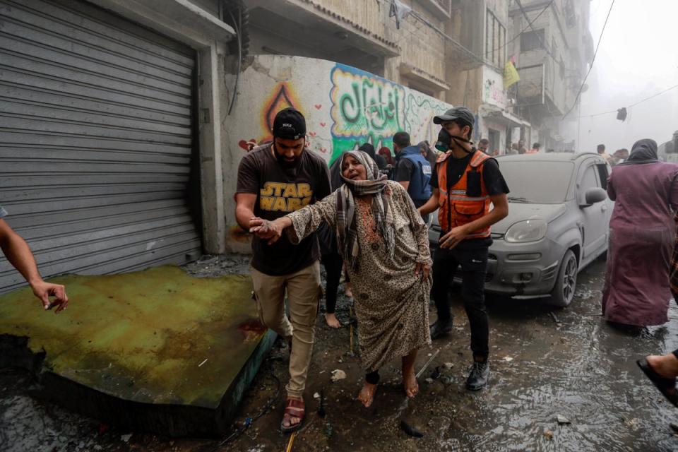 People help evacuate a Palestinian woman following Israeli airstrikes that targeted her neighbourhood in Gaza City. (Copyright 2023 The Associated Press. All rights reserved.)