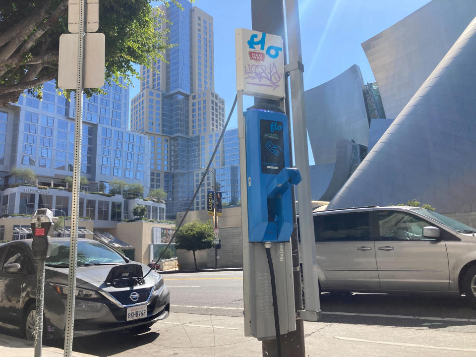 An electric vehicle charges on a publicly accessible pole-mounted charger in Los Angeles on Oct. 4, 2022. Los Angeles is a leader among U.S. cities in installing publicly accessible chargers, including 450 on city street light poles and 50 on power poles. But demand in Los Angeles and elsewhere far exceeds supply when it comes to charging access for EV owners who rent and don't have a private garage in which to power up their car. (AP Photo/Eugene Garcia)