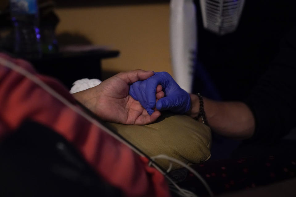 Hammond sujeta la mano de una paciente para calmarla en su domicilio de Placentia. (Foto: Jae C. Hong / AP).