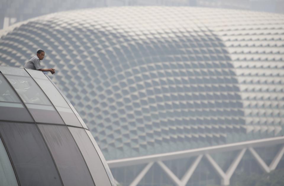 Man looks on near the Esplanade theatres shrouded by haze in Singapore