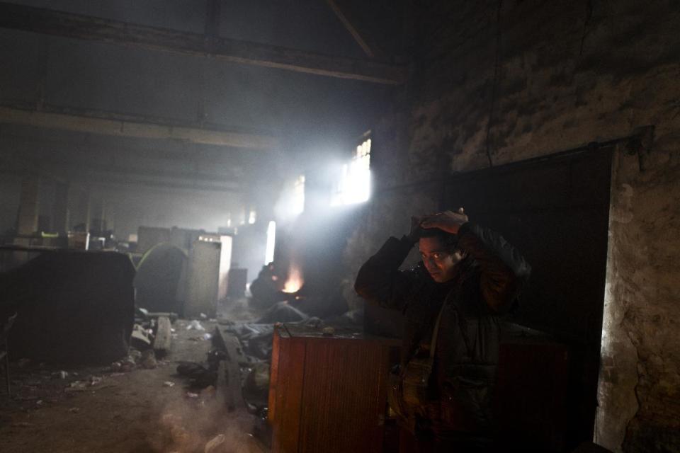 A migrant combs his hair after waking up in an abandoned warehouse where he and other migrants have taken refuge in Belgrade, Serbia, Wednesday, Feb. 1, 2017. Hundreds of migrants have been sleeping rough in freezing conditions in central Belgrade looking for ways to cross the heavily guarded EU borders. (AP Photo/Muhammed Muheisen)