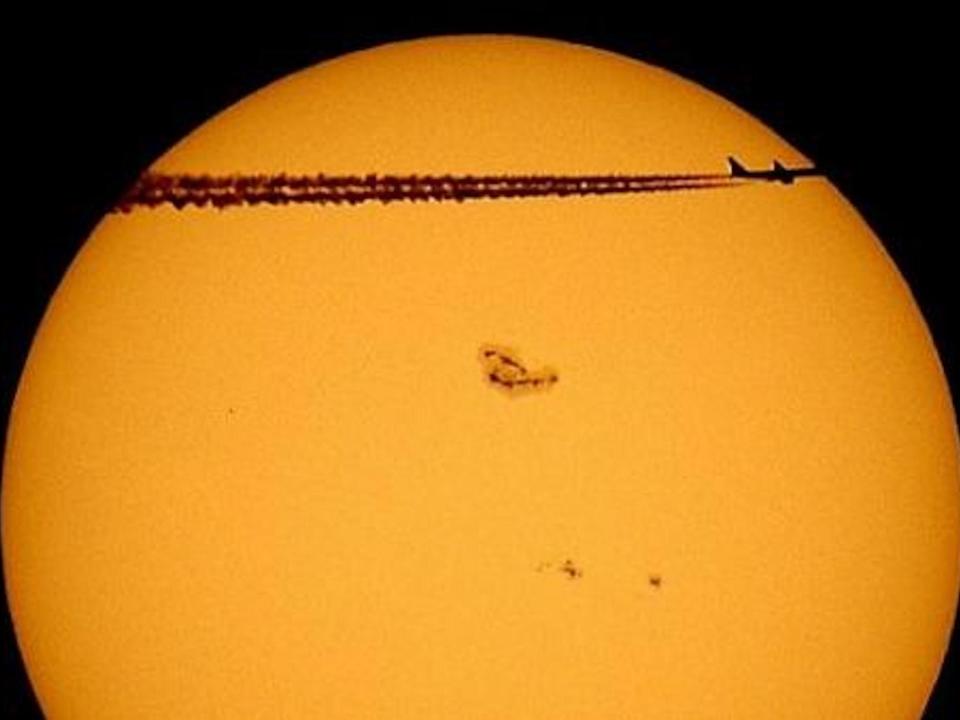 A sunstop is seen on the sun as a passing plane flies before it