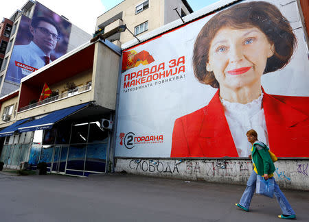 A woman passes election campaign posters of the opposition presidential candidate Gordana Dafkova-Siljanovska and ruling party candidate Stevo Pendarovski for presidential election on April 21 in Skopje, North Macedonia April 19, 2019. REUTERS/Ognen Teofilovski