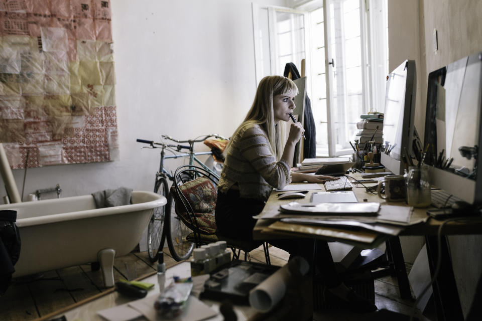 Woman working in a cluttered room. (Getty Images)