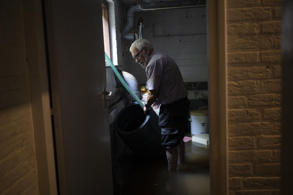 Wiel de Bie pumps water out of his flooded basement, in the town of Brommelen, Netherlands, Saturday, July 17, 2021. In the southern Dutch province of Limburg, which also has been hit hard by flooding, troops piled sandbags to strengthen a 1.1-kilometer (0.7 mile) stretch of dike along the Maas River, and police helped evacuate low-lying neighborhoods. (AP Photo/Bram Janssen)